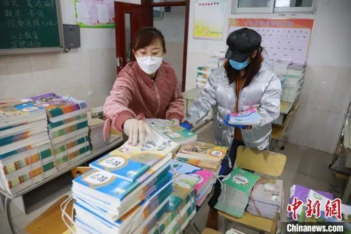 图为老师们分类整理新学期教材。 李捷 摄
